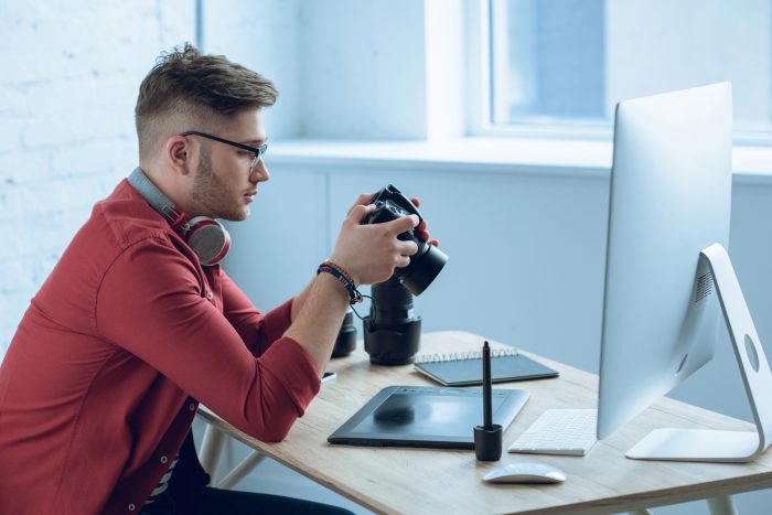 photographer analyzing his camera in front of the monitor