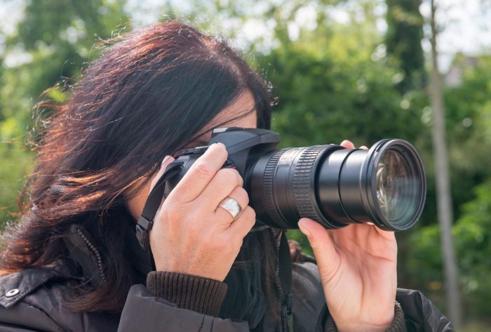 woman manually focusing her camera's lens