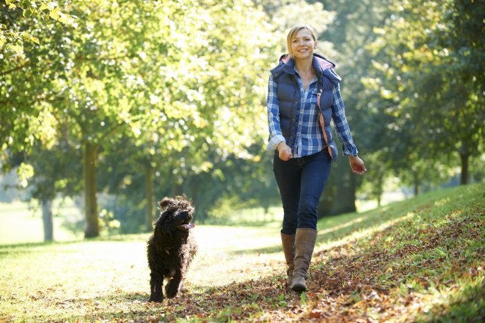 female poses by walking together with her dog