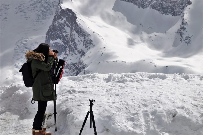 girl taking photos on a snowy mountain
