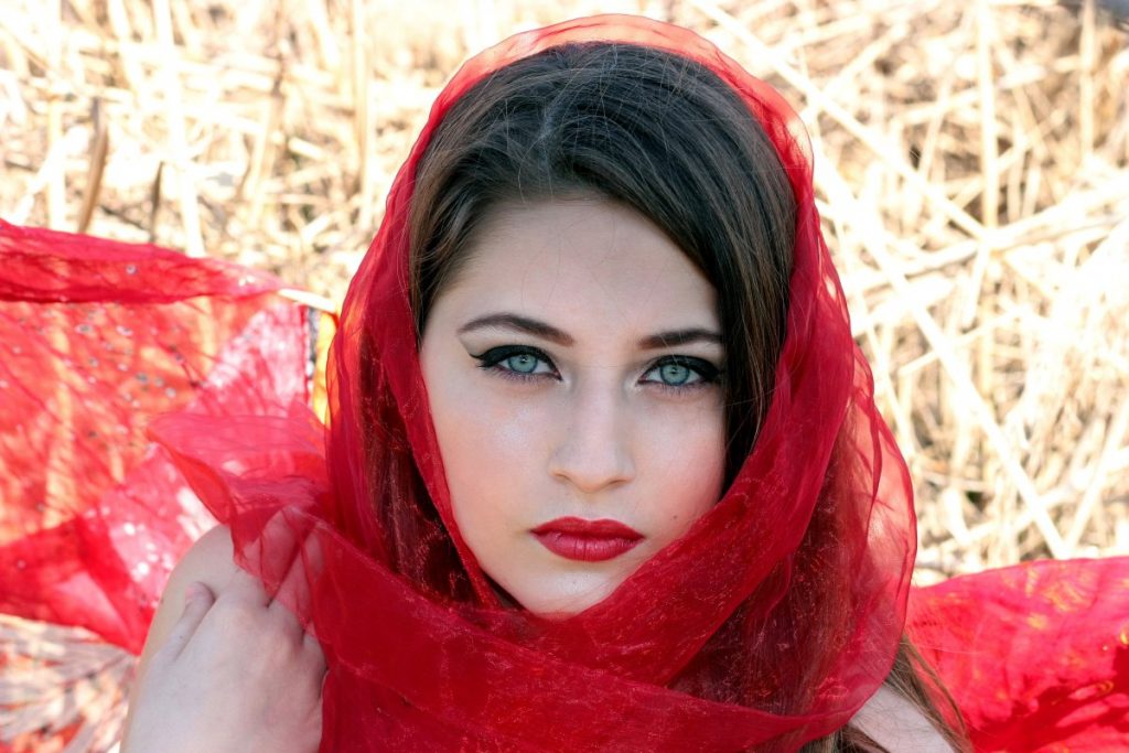 portrait of a stunning woman with green eyes wrapped in red