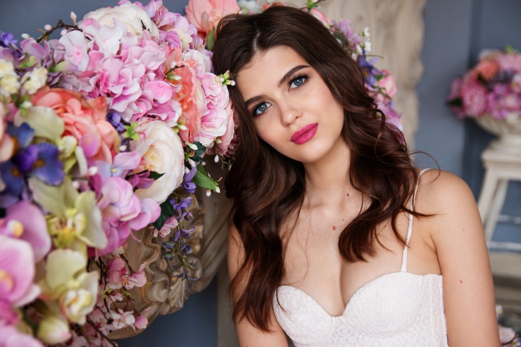 portrait of a bride next to flower arrangements