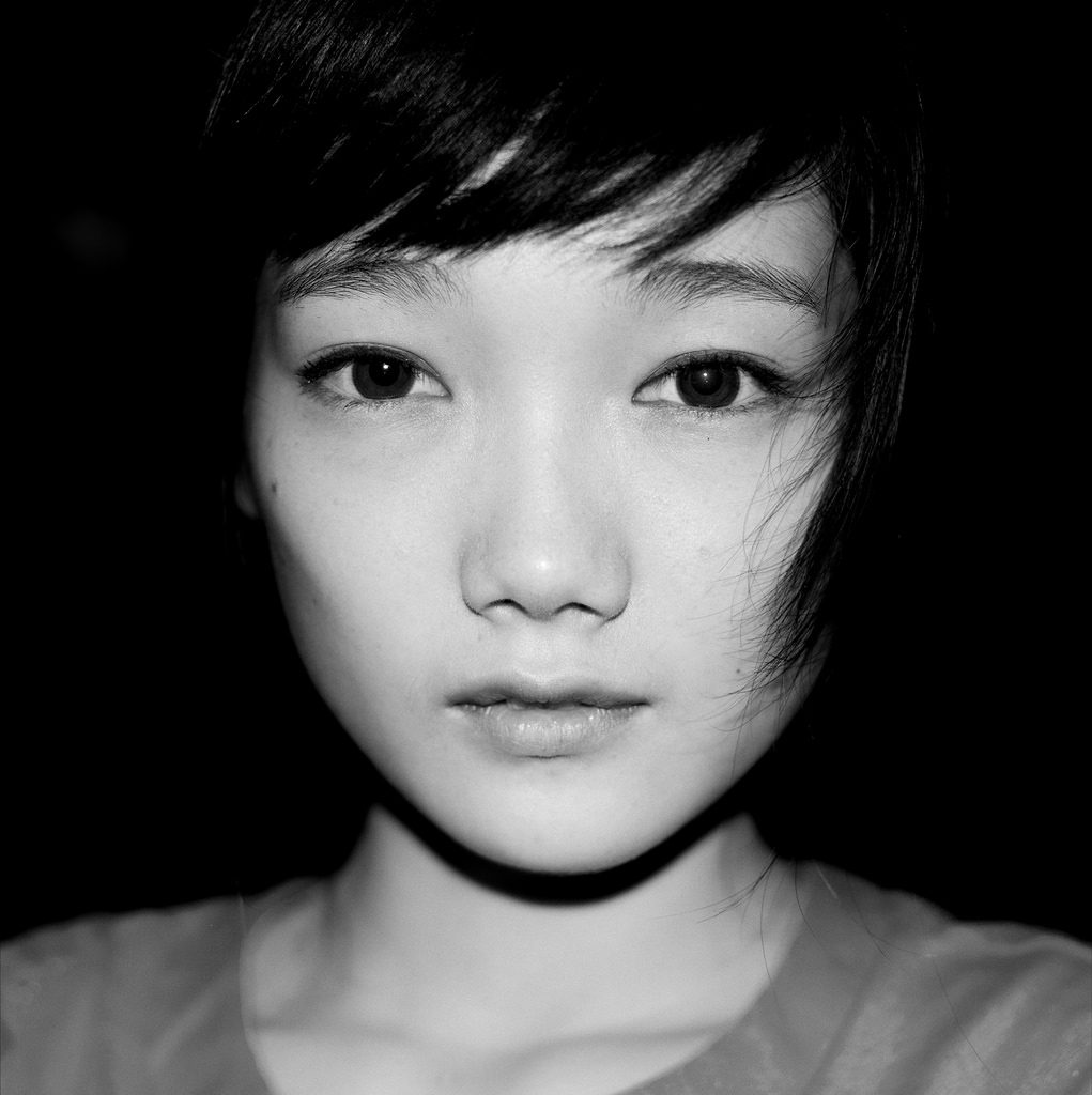 black and white up close portrait with flash of a young girl with pretty eyes