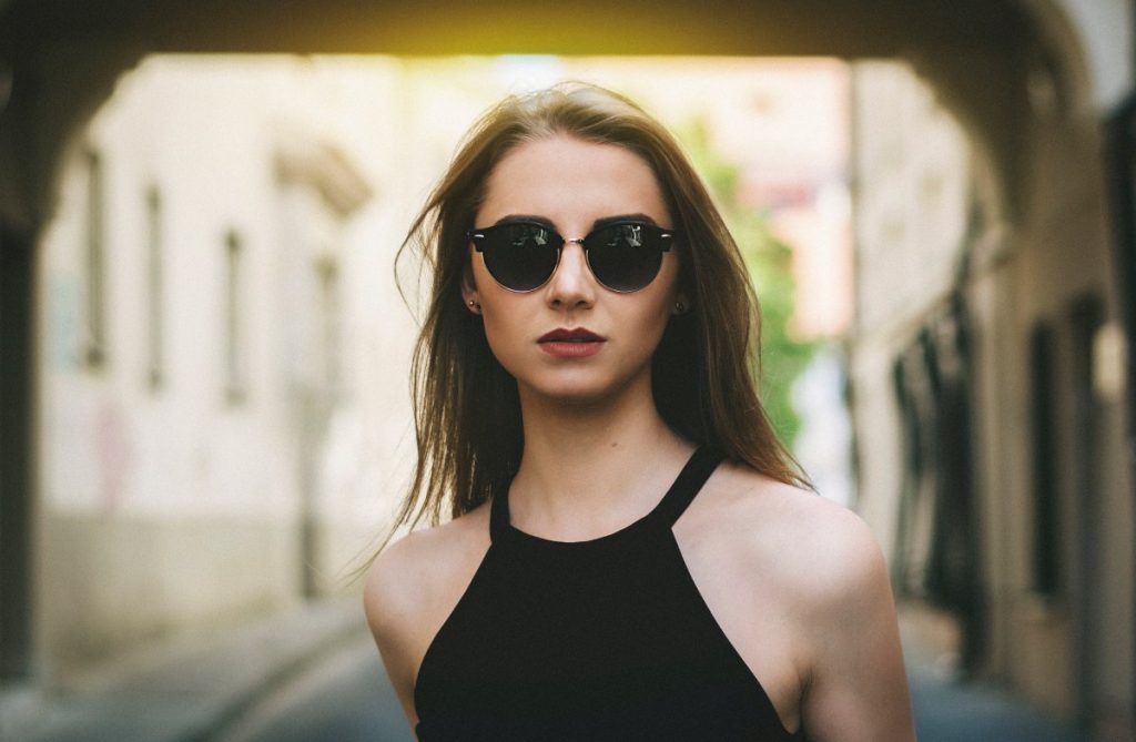 portrait of a woman wearing sunglasses being framed by architecture